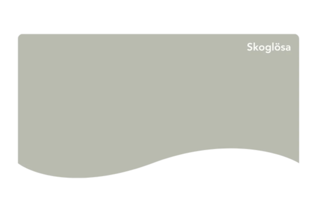 Ett rektangulärt färgprov med en subtil våg längs den nedre kanten, med en dämpad grågrön kulör märkt Skoglösa i vit text i det övre högra hörnet.
